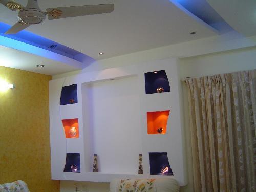 Living room false ceiling with colorful alcoves - GharExpert